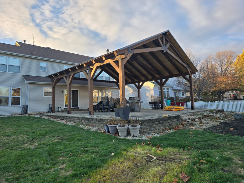 Gable-roofed backyard pavilion attached to home over patio