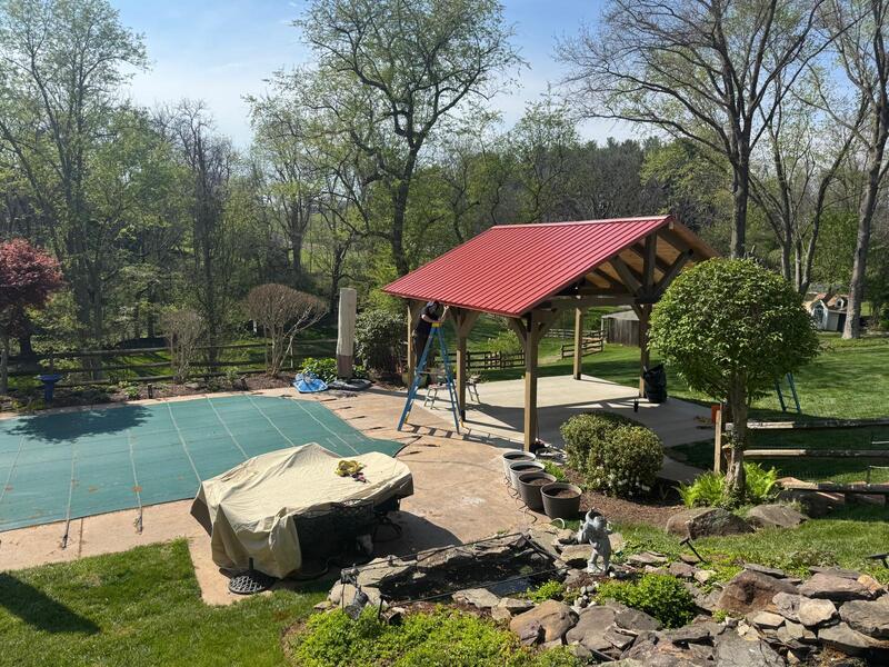 Freestanding pavilion with red metal roof poolside